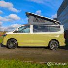 VW Transporter T7 campervan with full Spartan Campers conversion in white and military green, passenger side with the poptop roof up