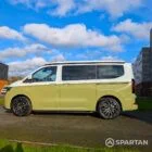 VW Transporter T7 campervan with full Spartan Campers conversion in white and military green, passenger side with the poptop roof down