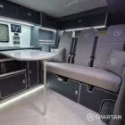 VW T7 Transporter with Spartan campervan conversion. Interior view with blizzard flooring, storm cloud and light grey kitchen showcasing the fabworx r&r bed and full length wardrobe