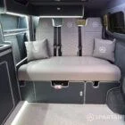 VW T7 Transporter with Spartan campervan conversion. Interior view with blizzard flooring, storm cloud and light grey kitchen showcasing the fabworx r&r bed