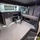 VW T7 Transporter with Spartan campervan conversion. Interior view with blizzard flooring, storm cloud and light grey kitchen showcasing the fabworx r&r bed and full length wardrobe with tall the storage doors open