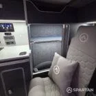 VW T7 Transporter with Spartan campervan conversion. Interior view with blizzard flooring, storm cloud and light grey kitchen showcasing the full length wardrobe and storage space