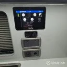 VW T7 Transporter with Spartan campervan conversion. Interior view with storm cloud and light grey kitchen showcasing the savvy van digital display, diesel night heartier, 12v and 230v sockets