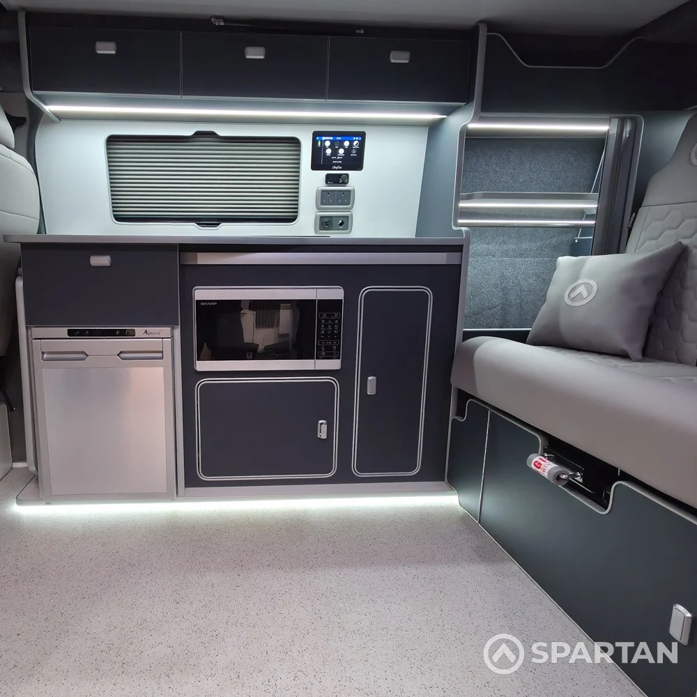 VW T7 Transporter with Spartan campervan conversion. Interior view with blizzard flooring, storm cloud and light grey kitchen and dust grey upholstery