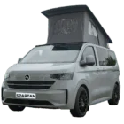 VW Transporter T7 campervan in light grey metallic with pop-top roof, passenger-side front quarter view.