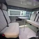 Spartan campers VW campervan with winter flooring, Italian Reed Green and Latte kitchen with Cookie upholstery. Fitted with a microwave, fridge/freezer, sink, wireless fast charger, rock and roll bed, and swivel and slide passenger bench seat