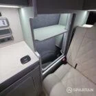 Spartan campers VW campervan with winter flooring, Italian Reed Green and Latte kitchen with Cookie upholstery. Fitted with a microwave, fridge/freezer, sink, wireless fast charger, rock and roll bed, and swivel and slide passenger bench seat