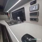 Spartan campers VW campervan with winter flooring, Italian Reed Green and Latte kitchen with Cookie upholstery. Fitted with a microwave, fridge/freezer, sink, wireless fast charger, rock and roll bed, and swivel and slide passenger bench seat