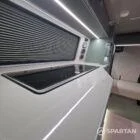 Spartan campers VW campervan with winter flooring, Italian Reed Green and Latte kitchen with Cookie upholstery. Fitted with a microwave, fridge/freezer, sink, wireless fast charger, rock and roll bed, and swivel and slide passenger bench seat