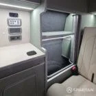 Spartan campers VW campervan with winter flooring, Italian Reed Green and Latte kitchen with Cookie upholstery. Fitted with a microwave, fridge/freezer, sink, wireless fast charger, rock and roll bed, and swivel and slide passenger bench seat