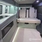 Spartan campers VW campervan with winter flooring, Italian Reed Green and Latte kitchen with Cookie upholstery. Fitted with a microwave, fridge/freezer, sink, wireless fast charger, rock and roll bed, and swivel and slide passenger bench seat