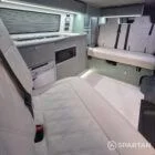 Spartan campers VW campervan with winter flooring, Italian Reed Green and Latte kitchen with Cookie upholstery. Fitted with a microwave, fridge/freezer, sink, wireless fast charger, rock and roll bed, and swivel and slide passenger bench seat