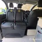 VW T7 Short wheelbase Spartan campervan interior with a passenger bench seat and mobiframe bed on rails. Winter flooring, latte and winchester oak kitchen