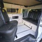 VW T7 Short wheelbase Spartan campervan interior with a passenger bench seat and mobiframe bed on rails. Winter flooring, latte and winchester oak kitchen