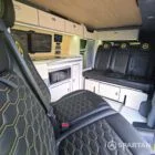 VW T7 Short wheelbase Spartan campervan interior with a passenger bench seat and mobiframe bed on rails. Winter flooring, latte and winchester oak kitchen