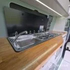 VW T7 SWB with full Spartan Campers conversion. winter flooring, latte and italian reed green kitchen, real wood worktop and cookie upholstery