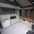 SWB VW T7 with Spartan Campers conversion, interior with winter flooring, latte and Italian reed green kitchen, liquor upholstery. Including a microwave, fridge/ freezer, rock and roll bed, double gas burner and sink