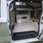 SWB VW T7 with Spartan Campers conversion, interior with winter flooring, latte and Italian reed green kitchen, liquor upholstery. Including a microwave, fridge/ freezer, rock and roll bed, double gas burner and sink