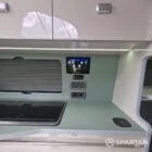 SWB VW T7 with Spartan Campers conversion, interior with winter flooring, latte and Italian reed green kitchen, liquor upholstery. Including a microwave, fridge/ freezer, rock and roll bed, double gas burner and sink