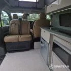 SWB VW T7 with Spartan Campers conversion, interior with winter flooring, latte and Italian reed green kitchen, liquor upholstery. Including a microwave, fridge/ freezer, rock and roll bed, double gas burner and sink