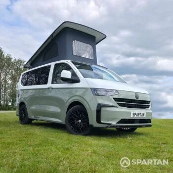 VW T7 SWB in Meadow Green front drivers quarter, pop top up, wheels turned