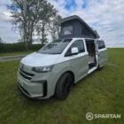 VW T7 in Meadow Green, front passengers quarter, pop top up, doors open