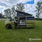 VW T7 SWB Spartan Campers campervan in warm metallic green, passengers side with pop top roof up and doors open