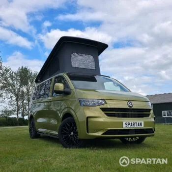 VW T7 SWB Spartan Campers campervan in warm metallic green, drivers front quarter with pop top roof up and wheels turned