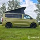 VW T7 SWB Spartan Campers campervan in warm metallic green, drivers side with pop top roof up
