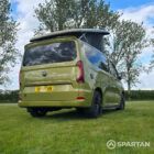 VW T7 SWB Spartan Campers campervan in warm metallic green, drivers rear quarter with pop top roof up