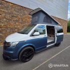 Passenger side profile of the Bamboo Green and Candy White Spartan campervan highlighting the sliding door, side bars and sleek camper conversion styling.
