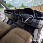 Front cabin showing the passenger double bench seat with matching Liquor upholstery leading into the Winter floor and camper conversion.