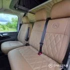Front cabin showing the passenger double bench seat with matching Liquor upholstery leading into the Winter floor and camper conversion.