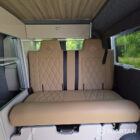 Rear seating area featuring the Liquor upholstered rock and roll bed with Winter flooring and overhead storage.