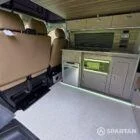 Kitchen area with Mocca and Driftwood cabinetry, integrated microwave, double gas burner and stainless steel sink.