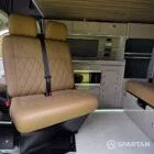 Passenger double bench seat and camper living space showing the open layout of the VW SWB Spartan conversion.